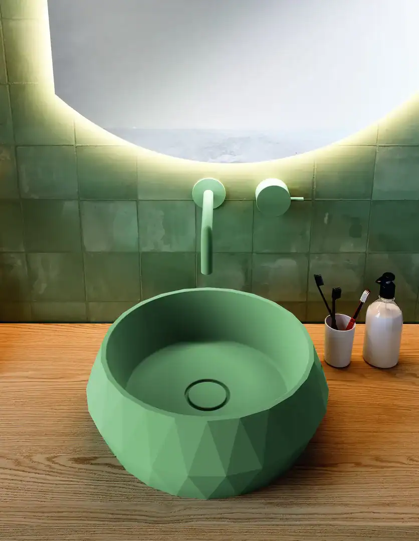 Un lavabo di design con superfici sfaccettate che riflette la luce